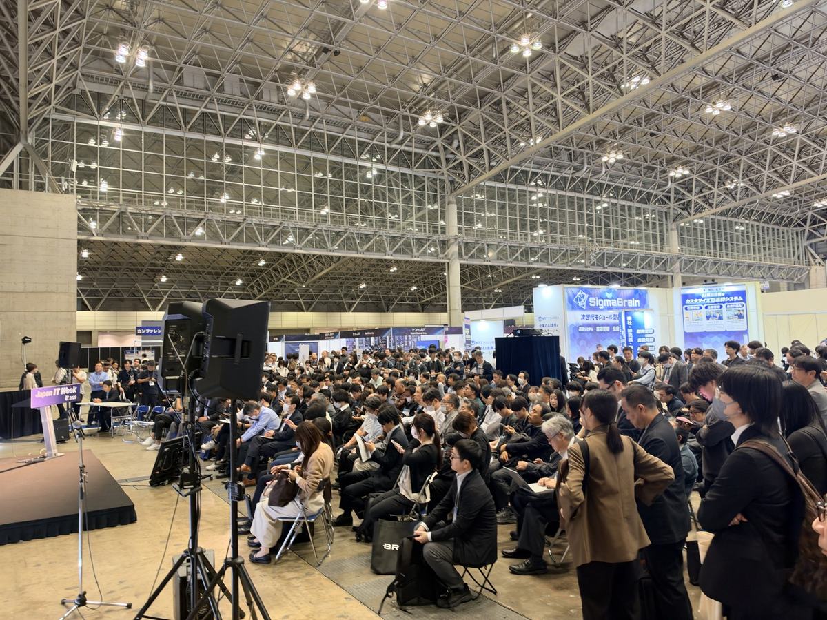 A packed seminar stage at Japan IT Week, with the audience standing at the back