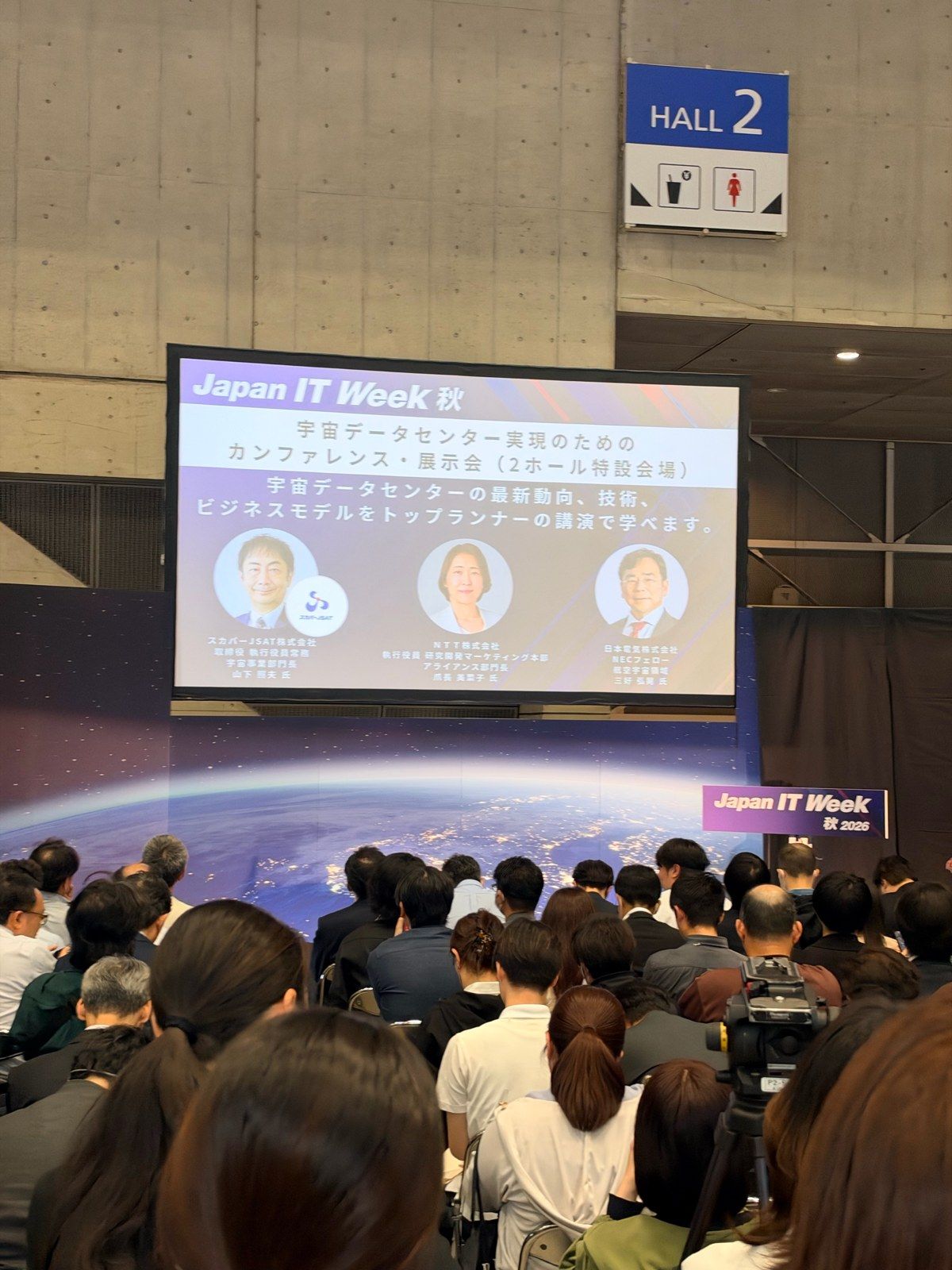 A conference session on data centres in space in Hall 2 at Japan IT Week, with speakers from SKY Perfect JSAT, NTT and NEC on the slide